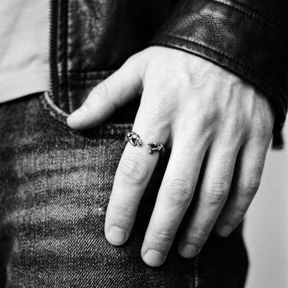 Young man's hand in a black leather jacket wearing the Ascension hands of God ring, black and white 35mm film