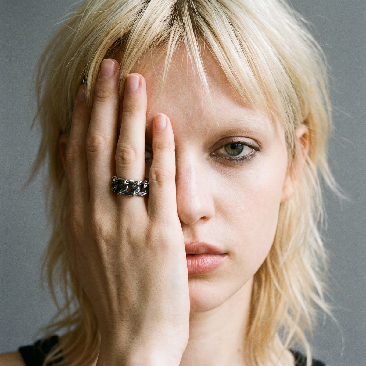 Blonde model with her hand over half her face wearing the Havana Cuban link ring