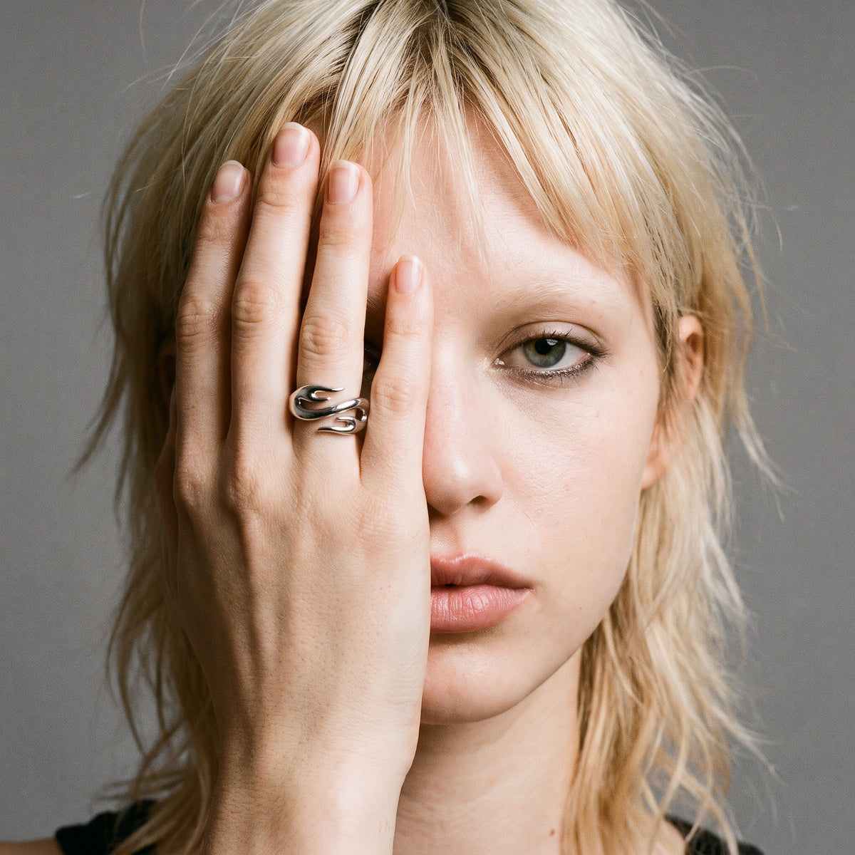 Blonde model with her hand over half her face wearing the Inferno flame ring