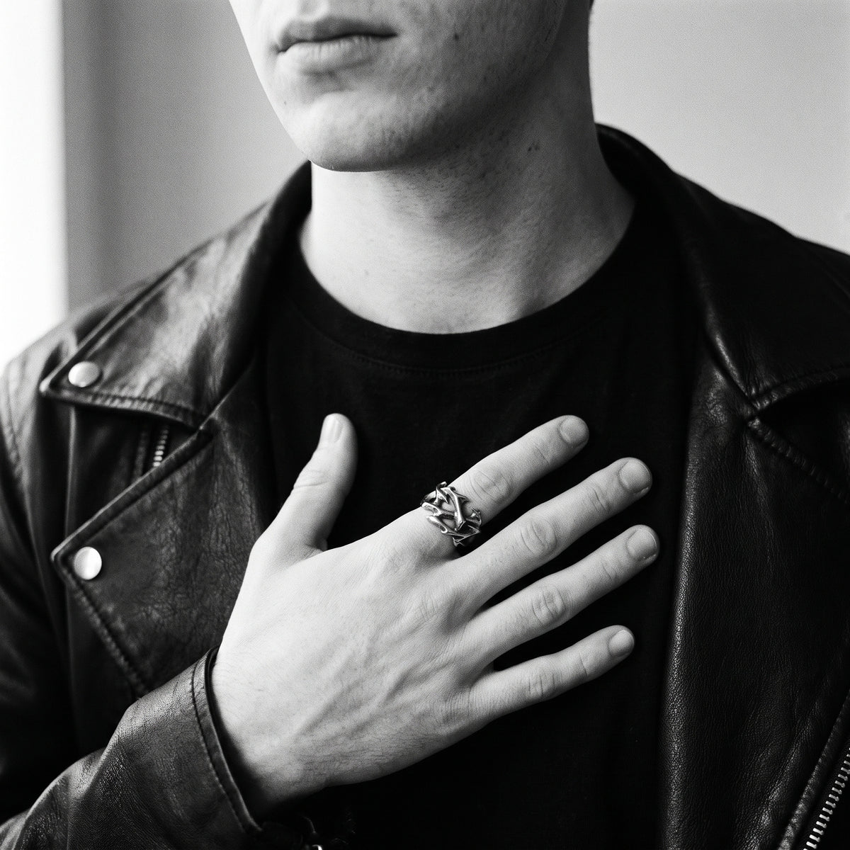 Black and white photo of a hand pressed to a chest wearing the Penance crown of thorns ring