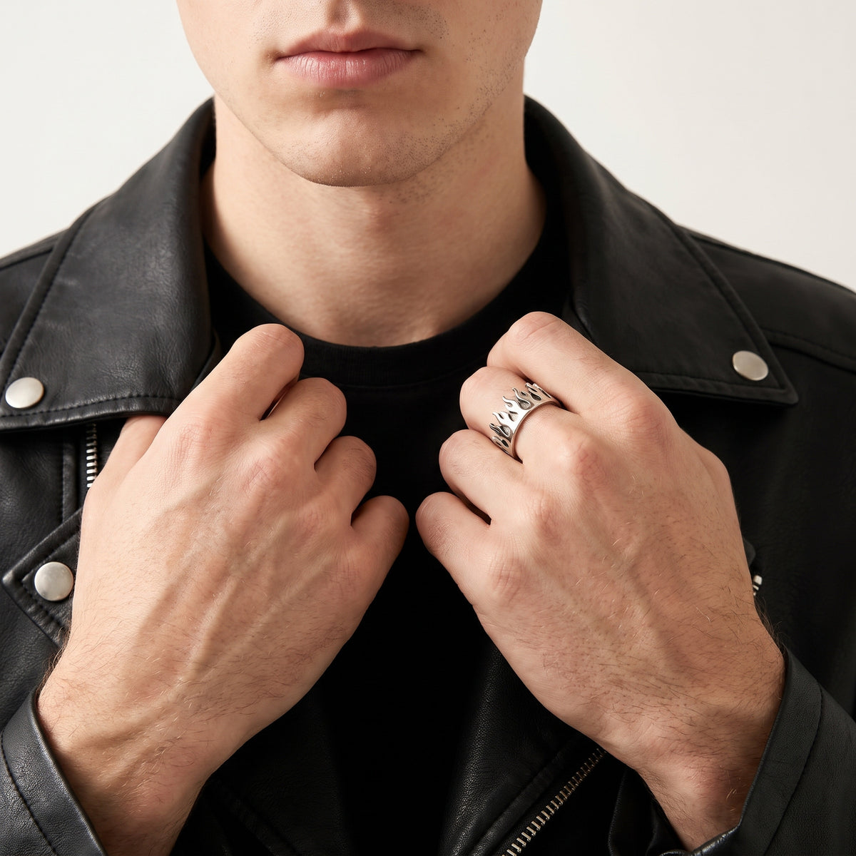 Man in a black leather jacket gripping the lapels, wearing the Pyre Flame Open Band Ring on his index finger