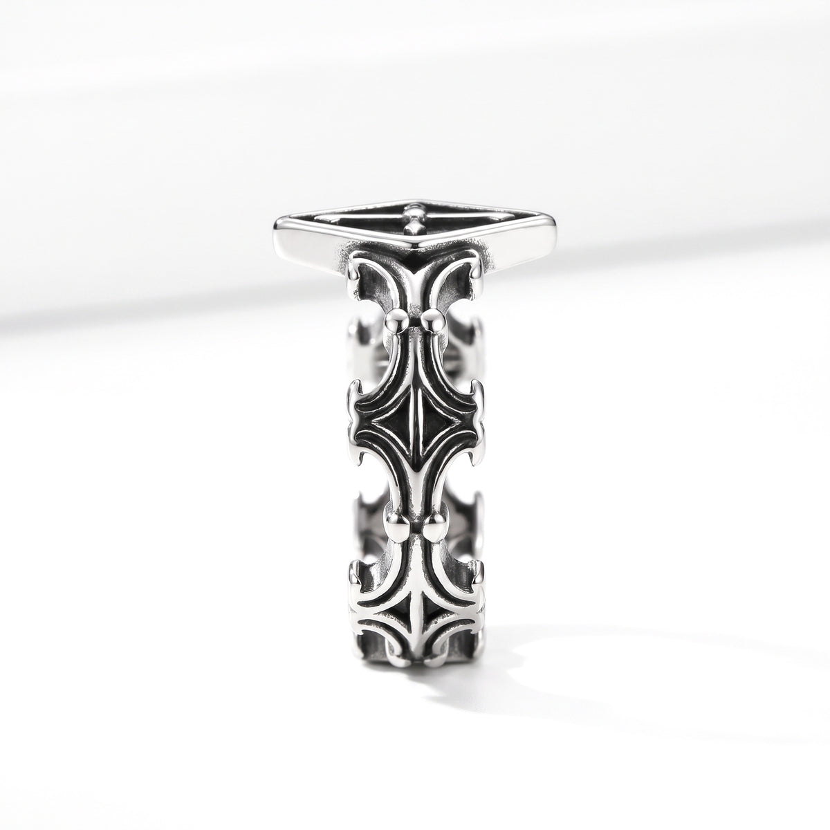 Relic rhombus cross ring in stainless steel, side profile showing the scrollwork band on white background