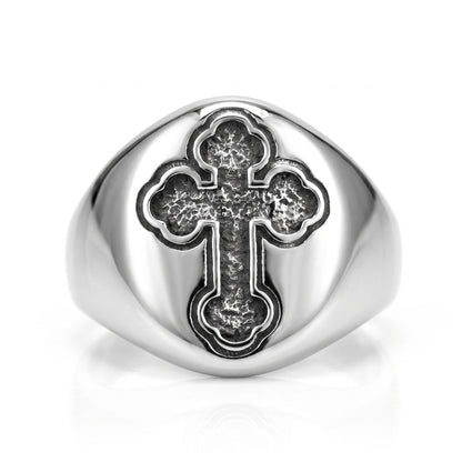 Reliquary Cross Amulet Ring, front view: stainless steel signet ring with a polished oval face and a dark antiqued trefoil cross, on white background