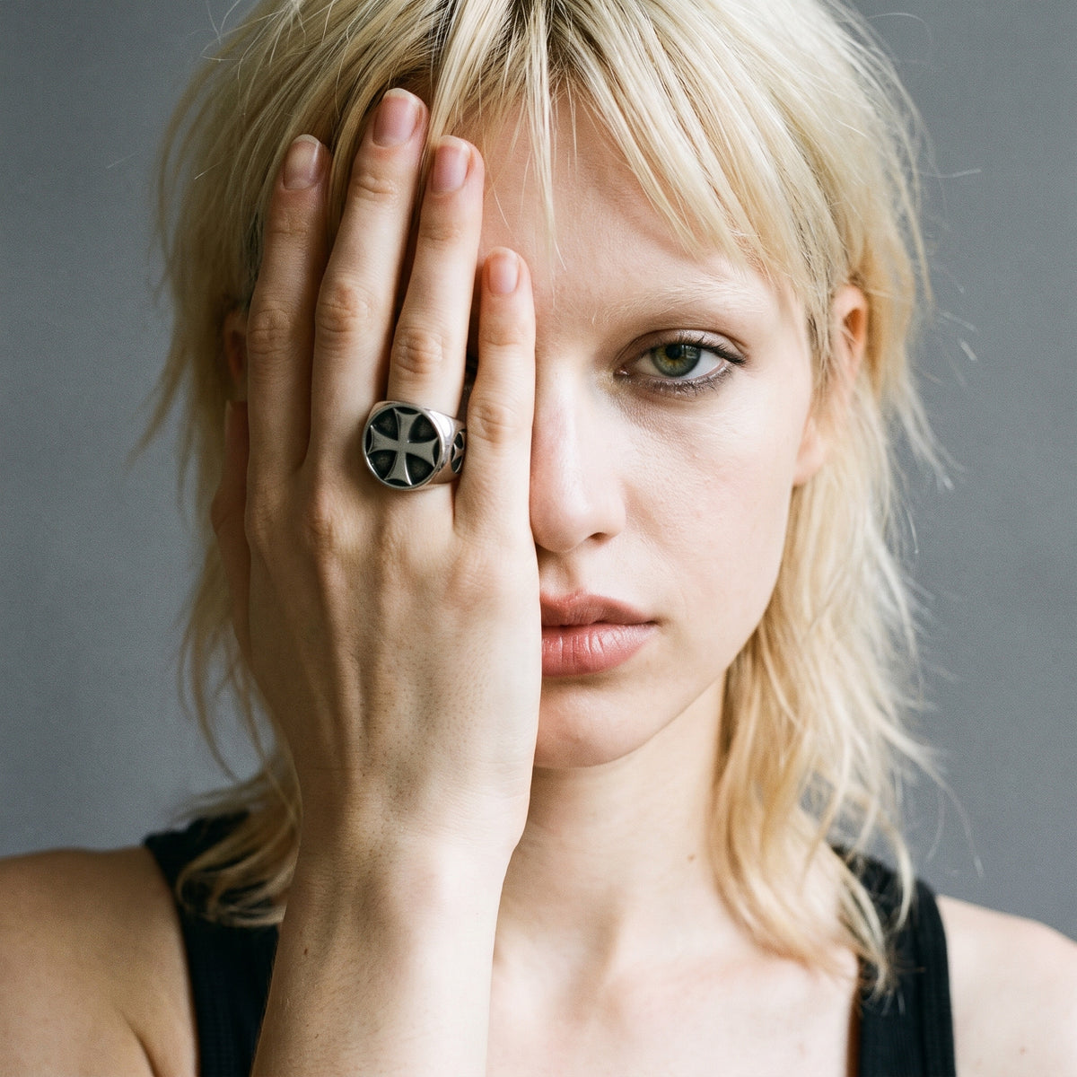 Blonde model with her hand over half her face wearing the Seneschal Templar cross signet ring