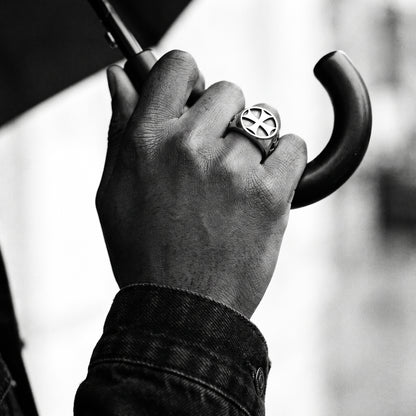 Black and white photo of a hand gripping a black umbrella handle wearing the Seneschal Templar cross signet ring