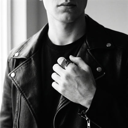 Young man's hand in a black leather jacket wearing the Seraph winged open ring, black and white 35mm film