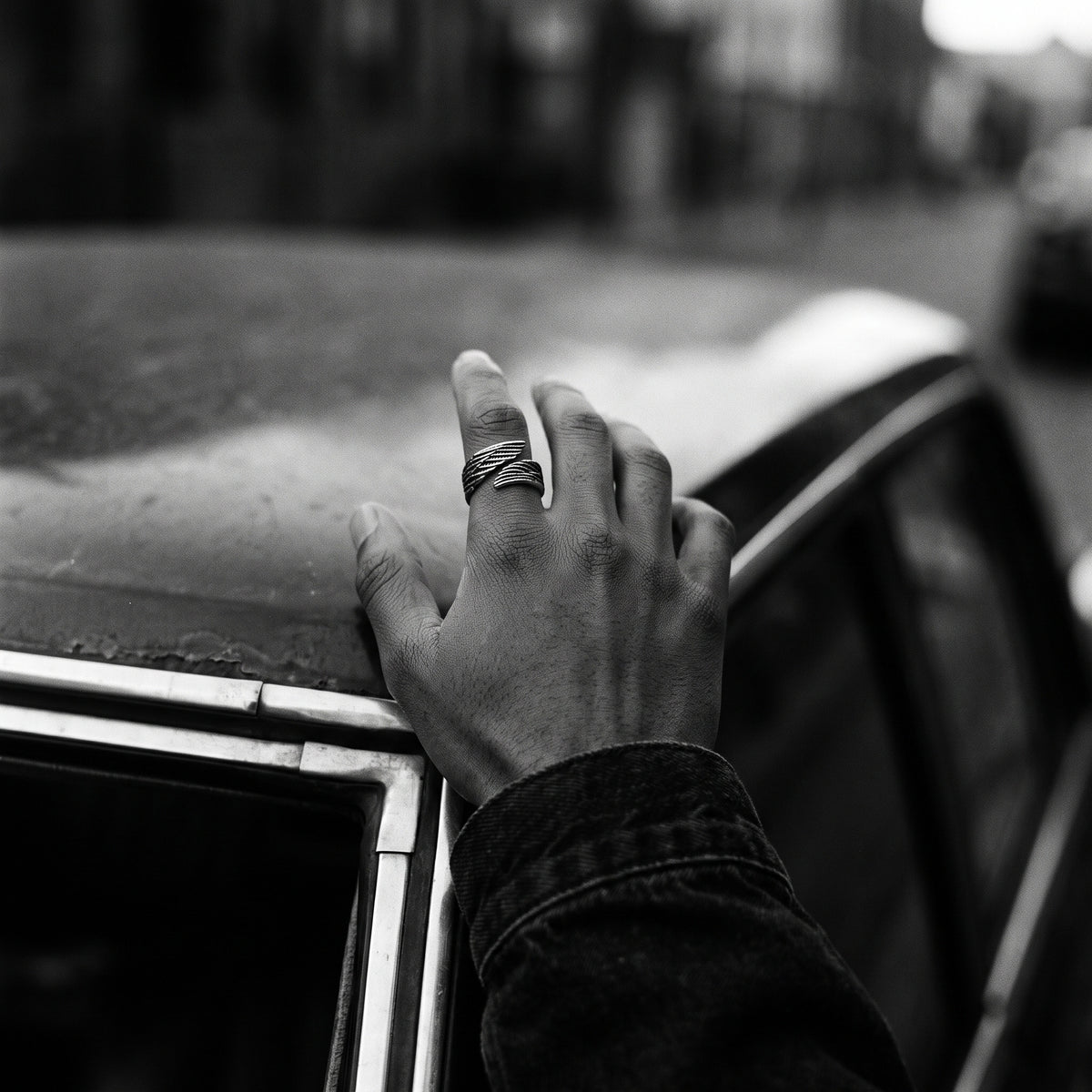 Man's hand wearing the Seraph winged open ring, black and white film photo