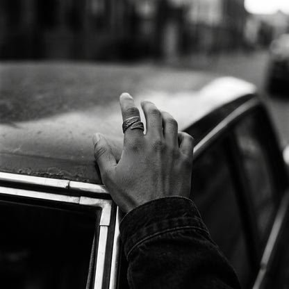 Man's hand wearing the Seraph winged open ring, black and white film photo