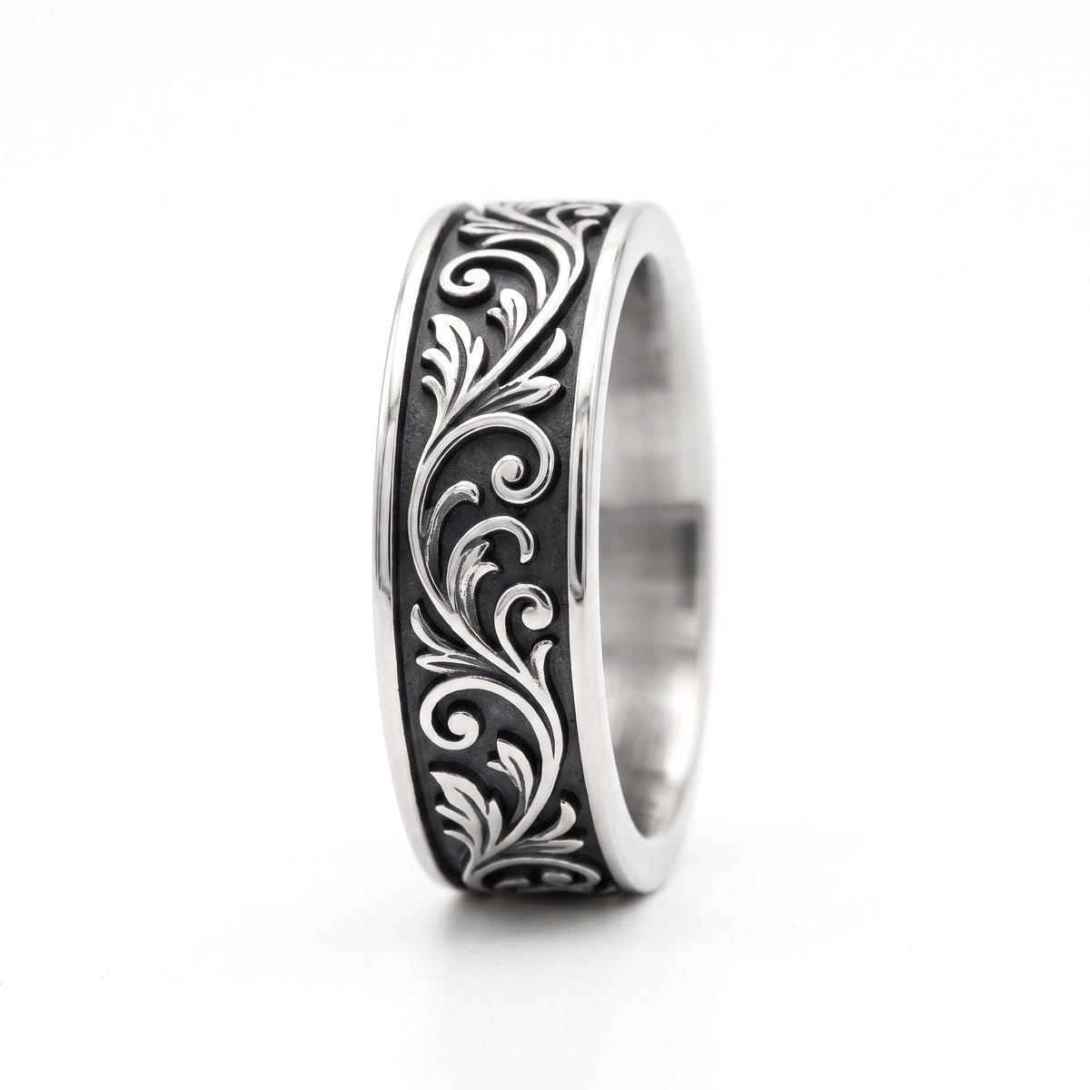 Skald Viking scrollwork band ring in stainless steel, side view showing the scroll pattern on white background