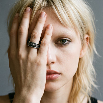 Blonde model with her hand over half her face wearing the Skald Viking scrollwork ring