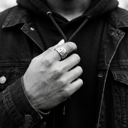 Man's hand on a hoodie drawstring wearing the Watcher eye ring, black and white film photo